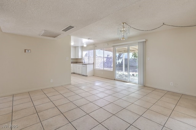 unfurnished room featuring baseboards, a textured ceiling, visible vents, and light tile patterned floors