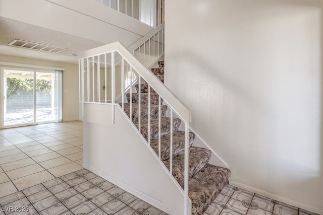 stairs featuring visible vents, tile patterned flooring, and baseboards