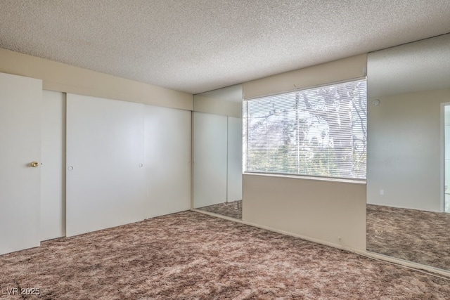 carpeted empty room with a textured ceiling