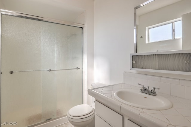 bathroom with backsplash, a shower stall, toilet, and vanity