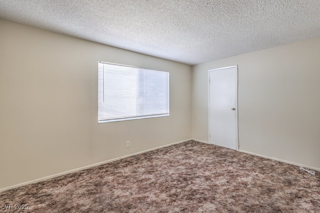 carpeted spare room featuring baseboards and a textured ceiling