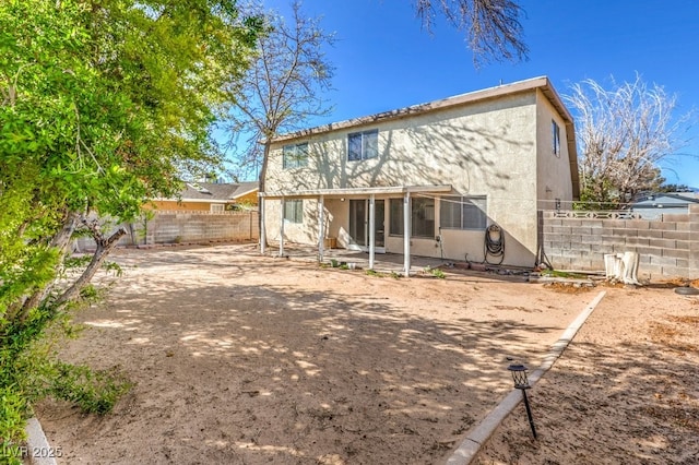 back of property featuring a fenced backyard, a patio, and stucco siding
