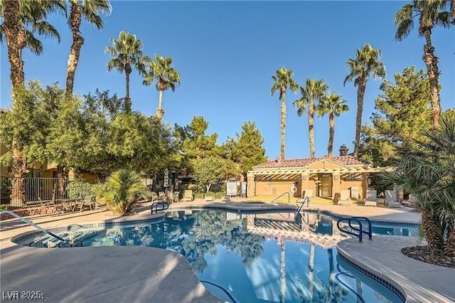 pool with a patio area and fence