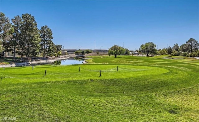 view of home's community with a yard, view of golf course, and a water view