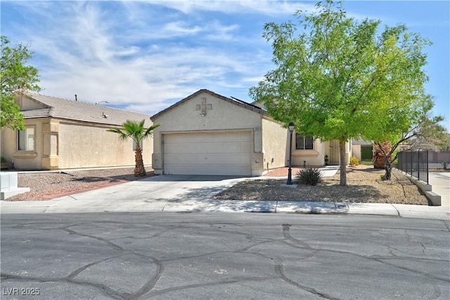 view of front of property with fence, an attached garage, stucco siding, and concrete driveway