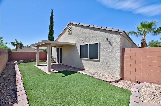 rear view of property featuring a yard, a fenced backyard, stucco siding, and a patio area