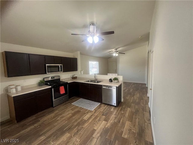 kitchen featuring dark wood-style floors, light countertops, a ceiling fan, a sink, and appliances with stainless steel finishes