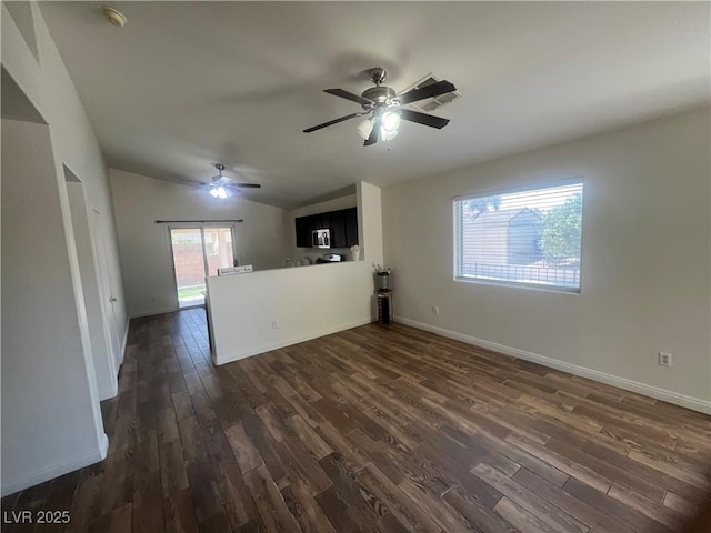 unfurnished living room with dark wood finished floors, vaulted ceiling, ceiling fan, and baseboards