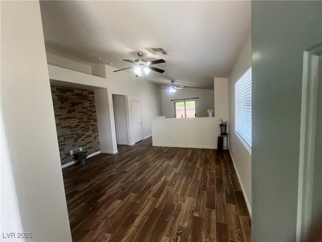 unfurnished living room with ceiling fan, baseboards, lofted ceiling, dark wood-style flooring, and visible vents