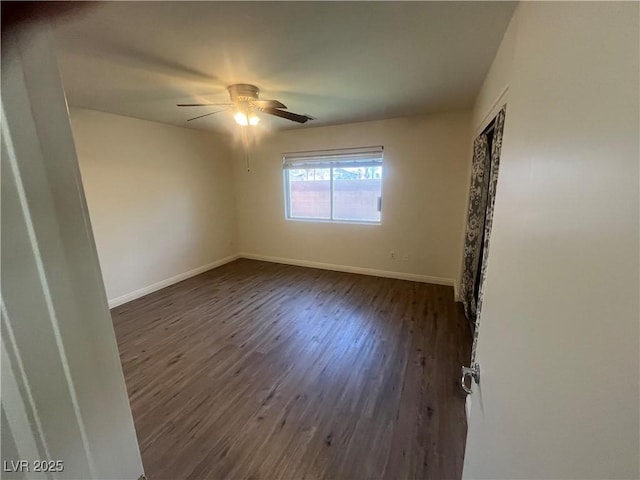 unfurnished room featuring dark wood finished floors, baseboards, and a ceiling fan