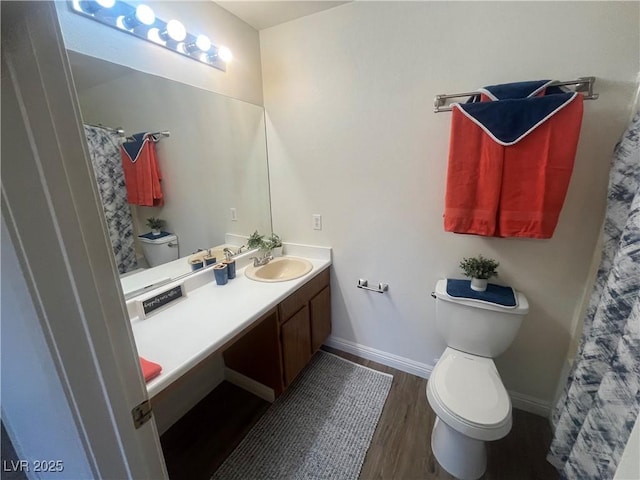full bath with baseboards, wood finished floors, toilet, and vanity