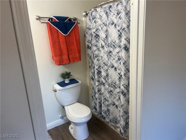 full bathroom with curtained shower, wood finished floors, and toilet