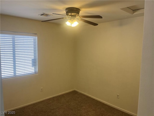 unfurnished room featuring baseboards, dark colored carpet, visible vents, and ceiling fan