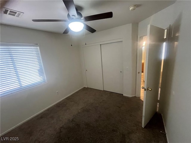unfurnished bedroom with baseboards, visible vents, carpet, a ceiling fan, and a closet