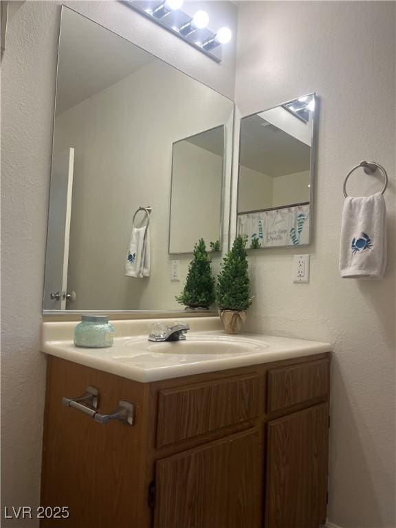 bathroom featuring a textured wall and vanity