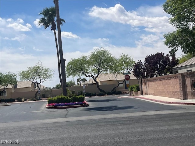 view of road featuring curbs, sidewalks, traffic signs, and a residential view