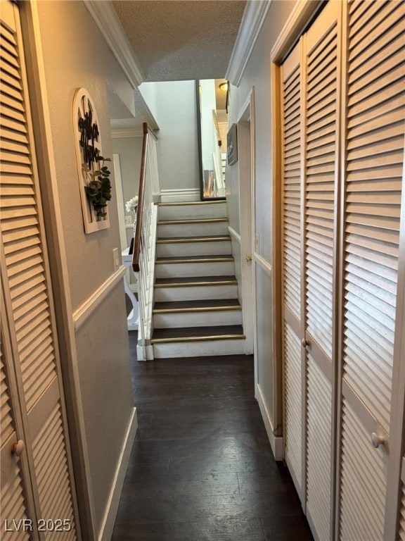 hall featuring dark wood-style flooring, ornamental molding, and stairway