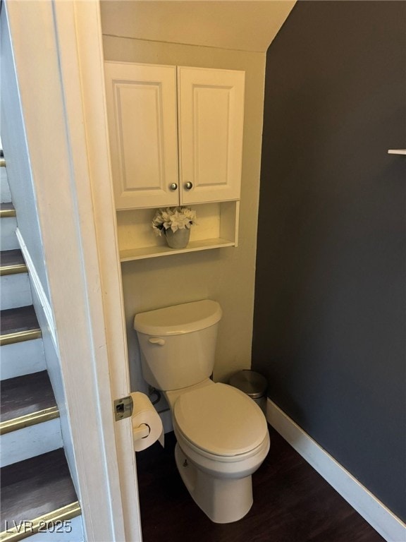 bathroom featuring toilet, baseboards, and wood finished floors