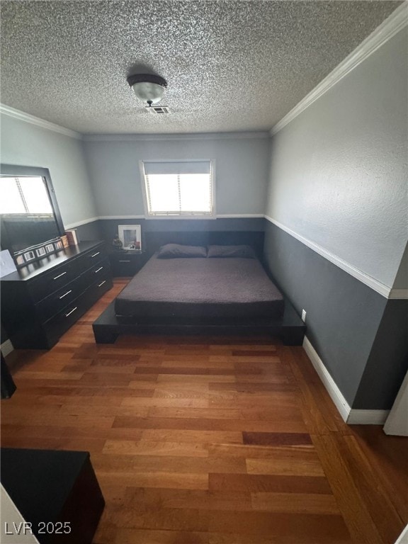 bedroom with multiple windows, wood finished floors, and crown molding