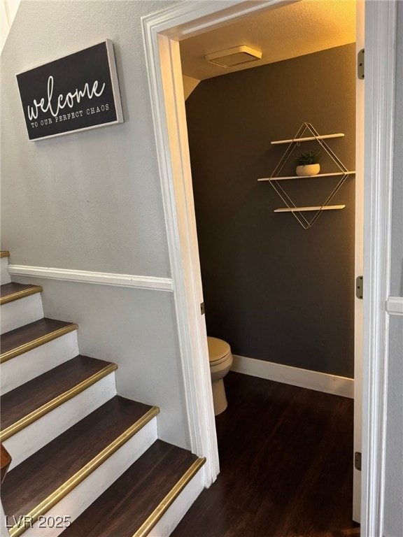 bathroom featuring toilet, wood finished floors, and baseboards