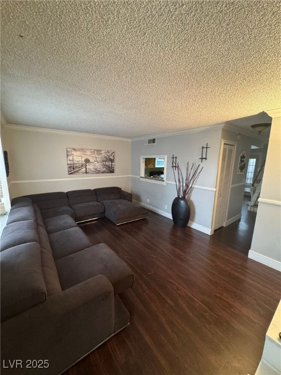 living room with visible vents, wood finished floors, and ornamental molding