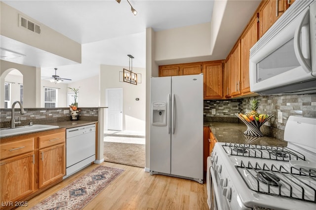 10550 W Alexander Rd Unit 2103, Las Vegas, NV 89129 - kitchen with white appliances, ceiling fan, brown cabinetry, light wood finished floors, and dark countertops