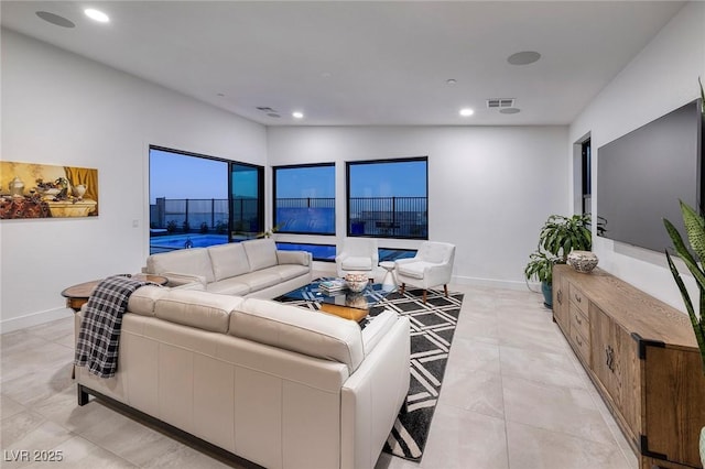 living room with baseboards, visible vents, and recessed lighting
