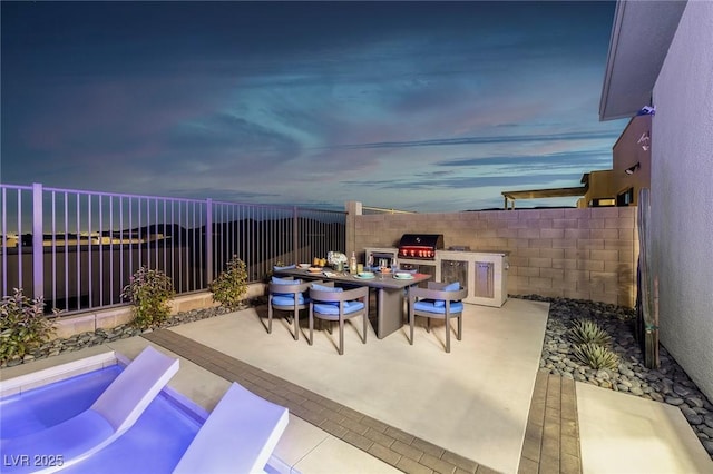 view of patio / terrace featuring an outdoor kitchen, grilling area, outdoor dining area, and a fenced backyard