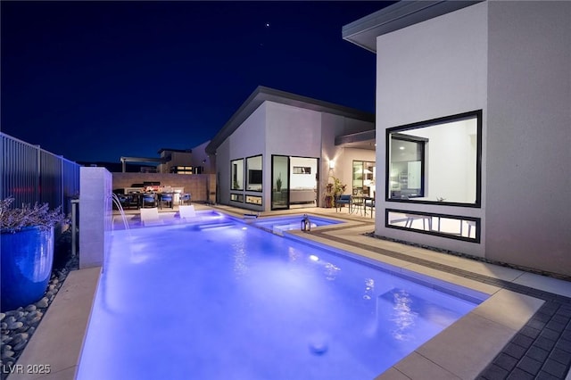 pool at twilight featuring an in ground hot tub, a fenced in pool, a fenced backyard, and a patio