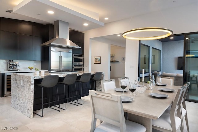 dining space featuring wine cooler and recessed lighting