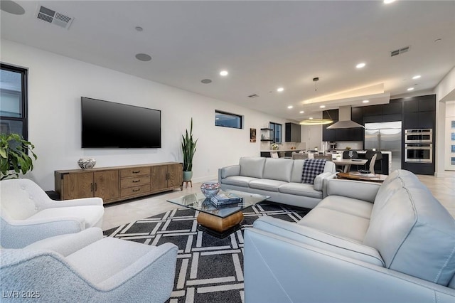 living room featuring baseboards, visible vents, and recessed lighting