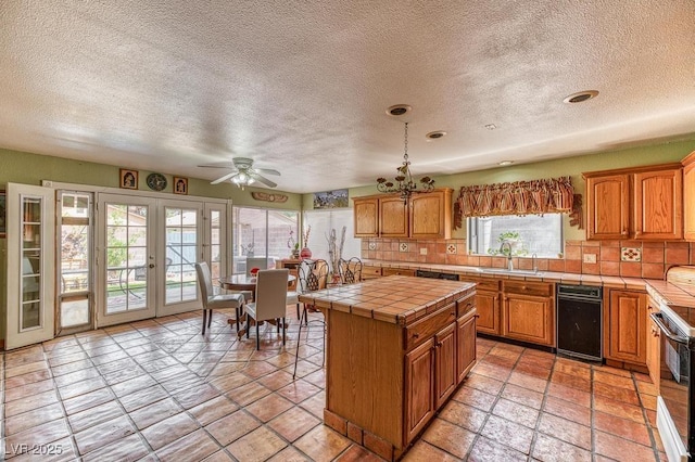 kitchen with a sink, tile counters, decorative backsplash, and french doors
