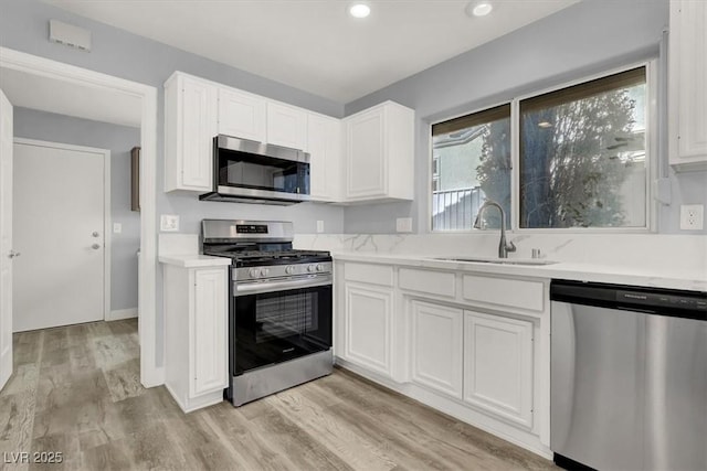 kitchen featuring white cabinetry, a sink, light countertops, and appliances with stainless steel finishes