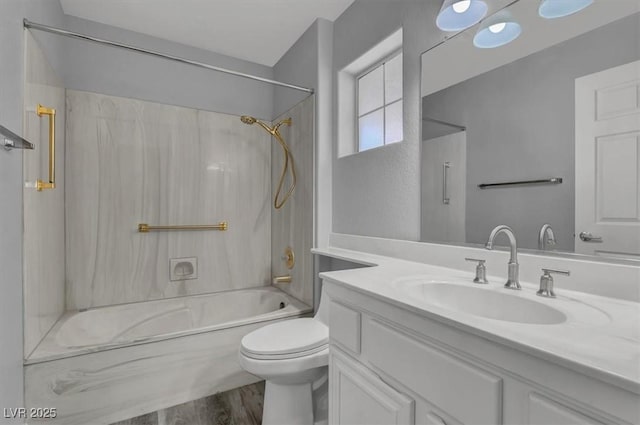 bathroom with toilet, wood finished floors, vanity, and shower / washtub combination
