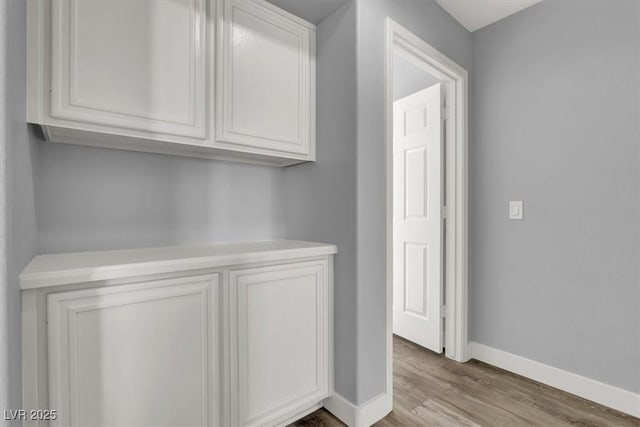 interior space featuring baseboards and wood finished floors