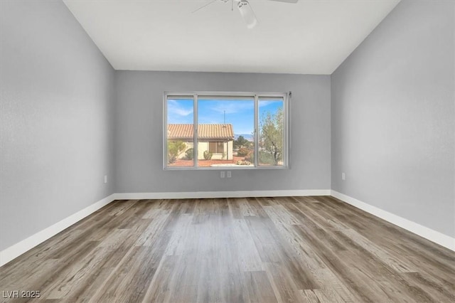 empty room with baseboards, ceiling fan, and wood finished floors