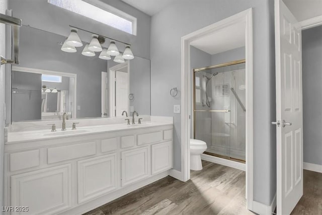 bathroom featuring a sink, a shower stall, and wood finished floors