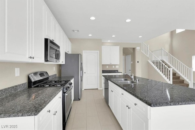 kitchen with white cabinetry, recessed lighting, a center island with sink, a sink, and appliances with stainless steel finishes