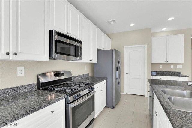 kitchen with visible vents, white cabinetry, a sink, and appliances with stainless steel finishes
