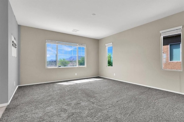 carpeted empty room featuring baseboards and visible vents
