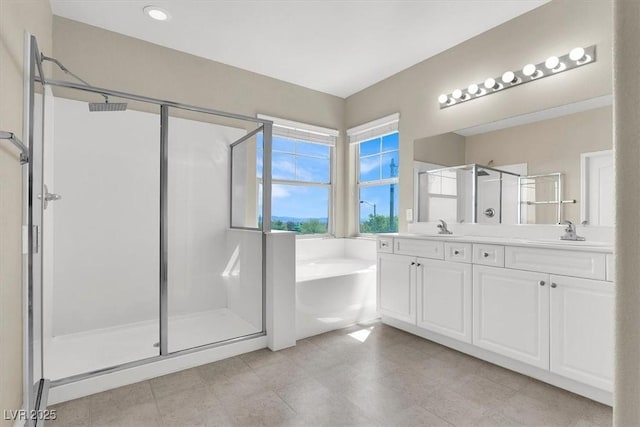 bathroom featuring a bath, double vanity, a sink, and a stall shower