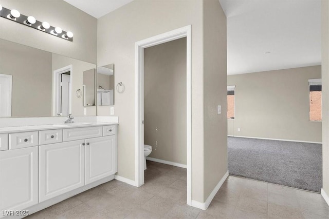 bathroom with baseboards, toilet, vanity, and tile patterned floors