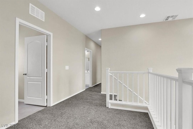 corridor with an upstairs landing, visible vents, recessed lighting, and carpet