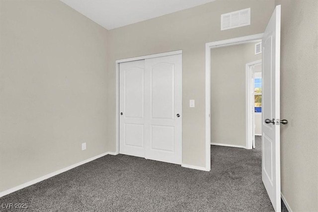 unfurnished bedroom featuring baseboards, dark carpet, and visible vents