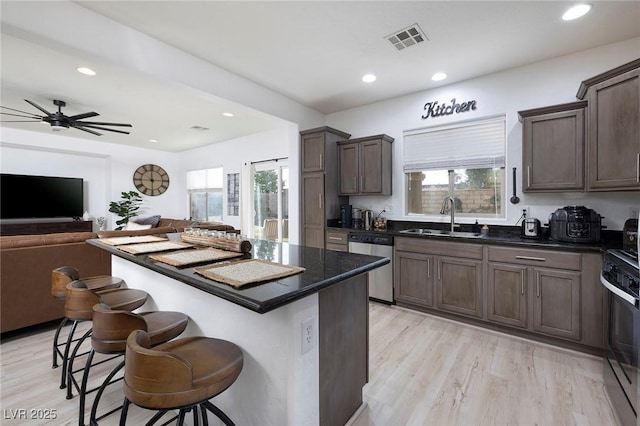 11913 Alava Ave, Las Vegas, NV 89138 - kitchen with stainless steel appliances, a kitchen breakfast bar, plenty of natural light, dark brown cabinetry, and recessed lighting
