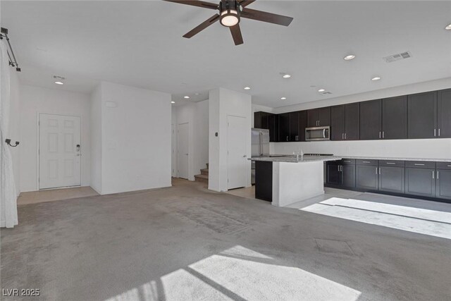 5589 Pico Ferrera Ct, Las Vegas, NV 89113 - kitchen featuring recessed lighting, ceiling fan, visible vents, stainless steel microwave, and light colored carpet