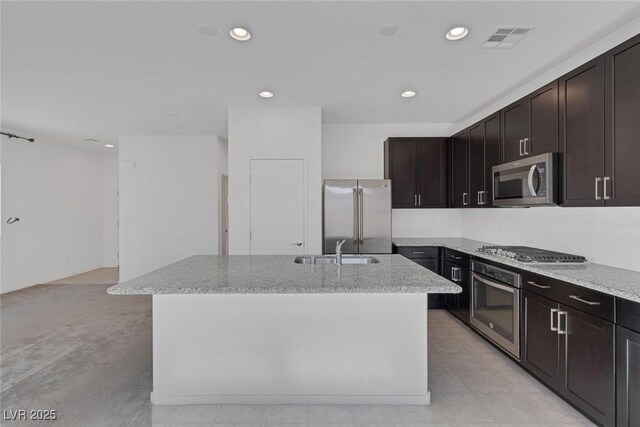 5589 Pico Ferrera Ct, Las Vegas, NV 89113 - kitchen featuring a sink, stainless steel appliances, light stone counters, visible vents, and an island with sink