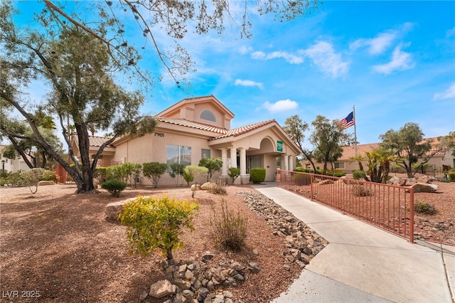 7900 Fossil Creek Ln Unit 103, Las Vegas, NV 89145 - mediterranean / spanish-style house with a fenced front yard, stucco siding, and a tile roof