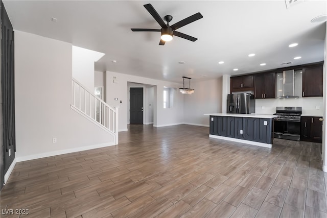 5940 Tamarack Lodge Ln, North Las Vegas, NV 89081 - kitchen featuring stainless steel appliances, open floor plan, ceiling fan, wall chimney range hood, and light countertops