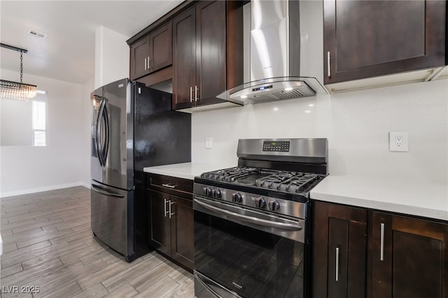 5940 Tamarack Lodge Ln, North Las Vegas, NV 89081 - kitchen featuring light countertops, wall chimney range hood, visible vents, dark brown cabinetry, and appliances with stainless steel finishes